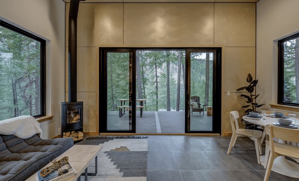 Interior view of new home from perspective of living area, looking out onto a deck through large glass doors