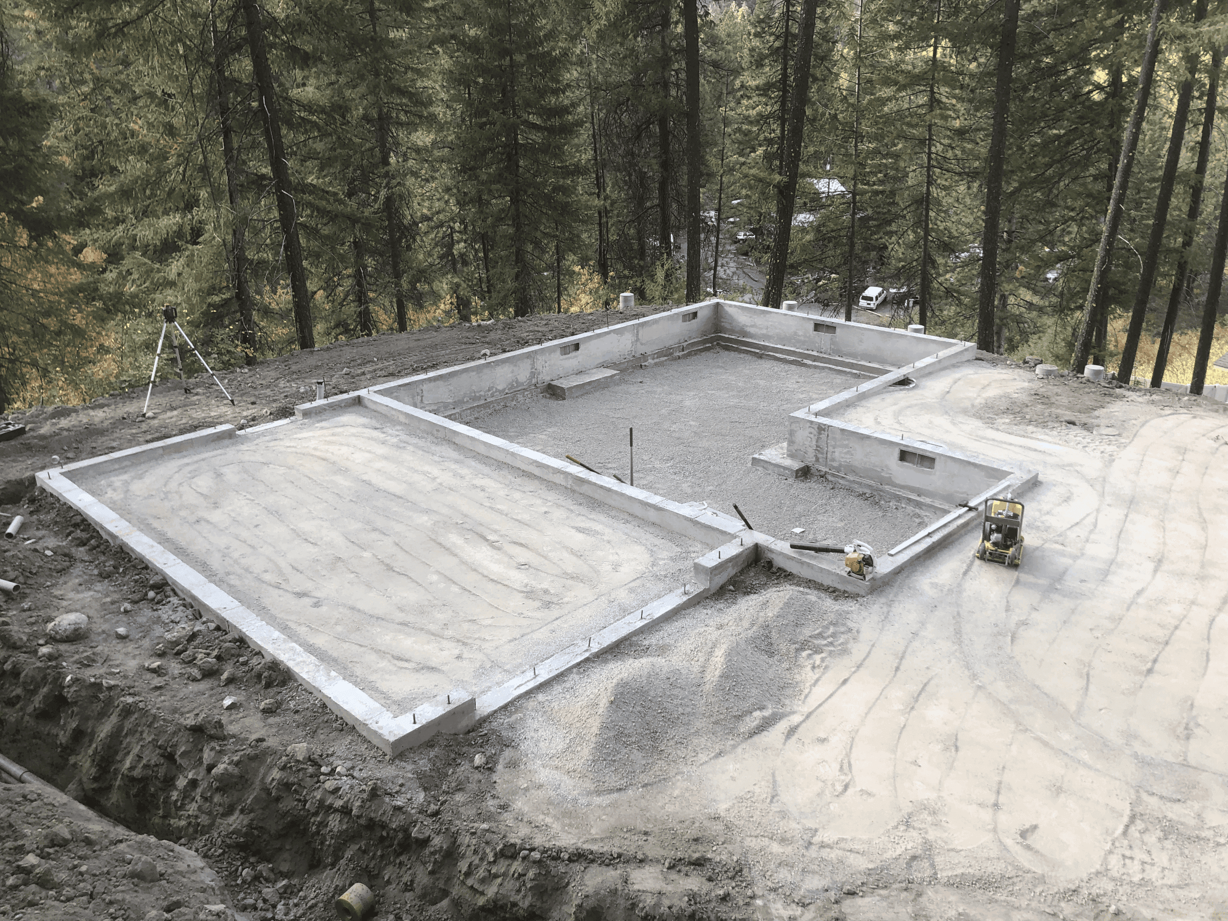Aerial view of foundation and footings for new construction of a residential home within a forested area