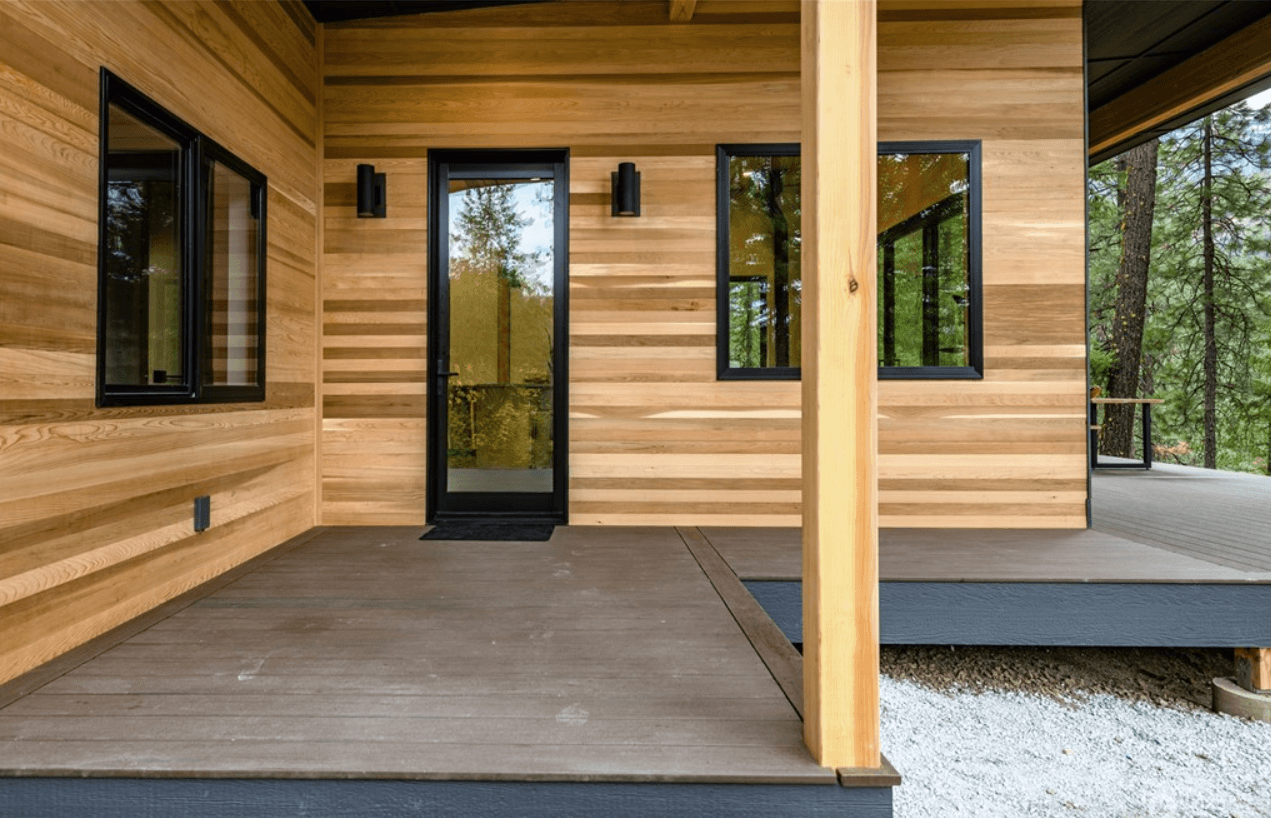 Close up of front deck of a modern home with a cedar-panel walled covered entryway