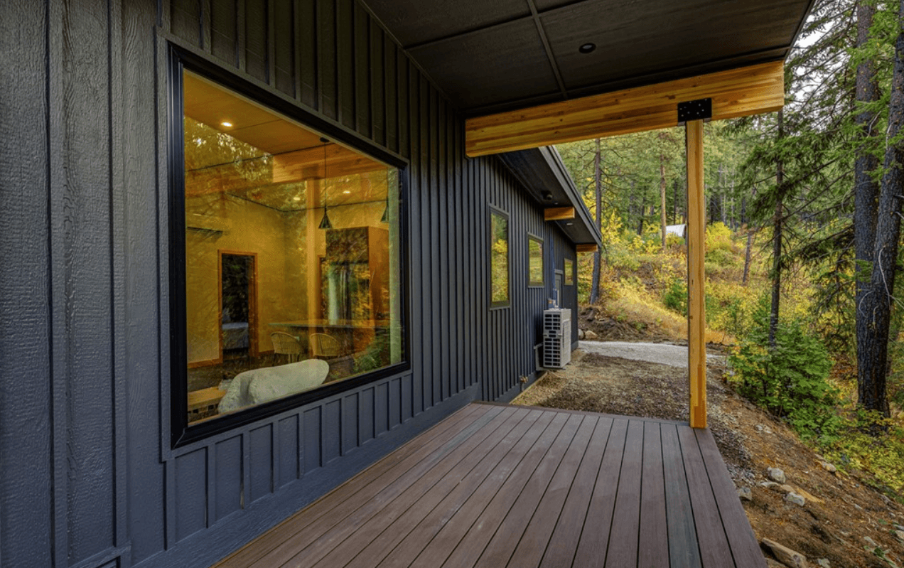 Side deck of newly constructed home with forested backdrop