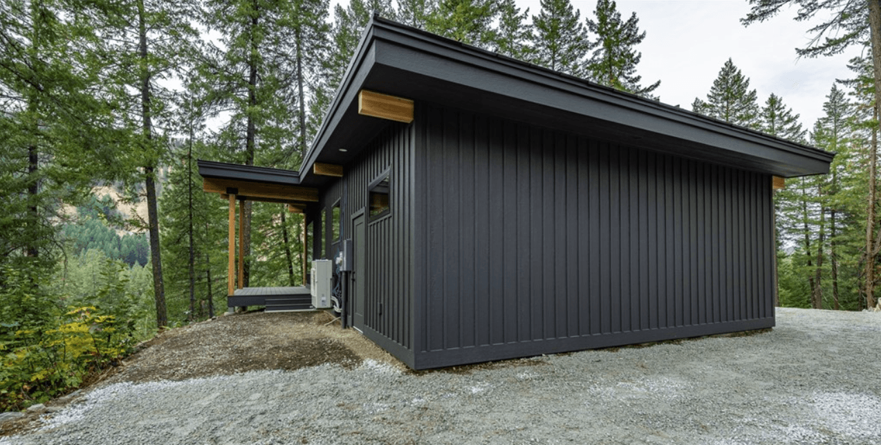 Side profile of newly constructed home with forested backdrop