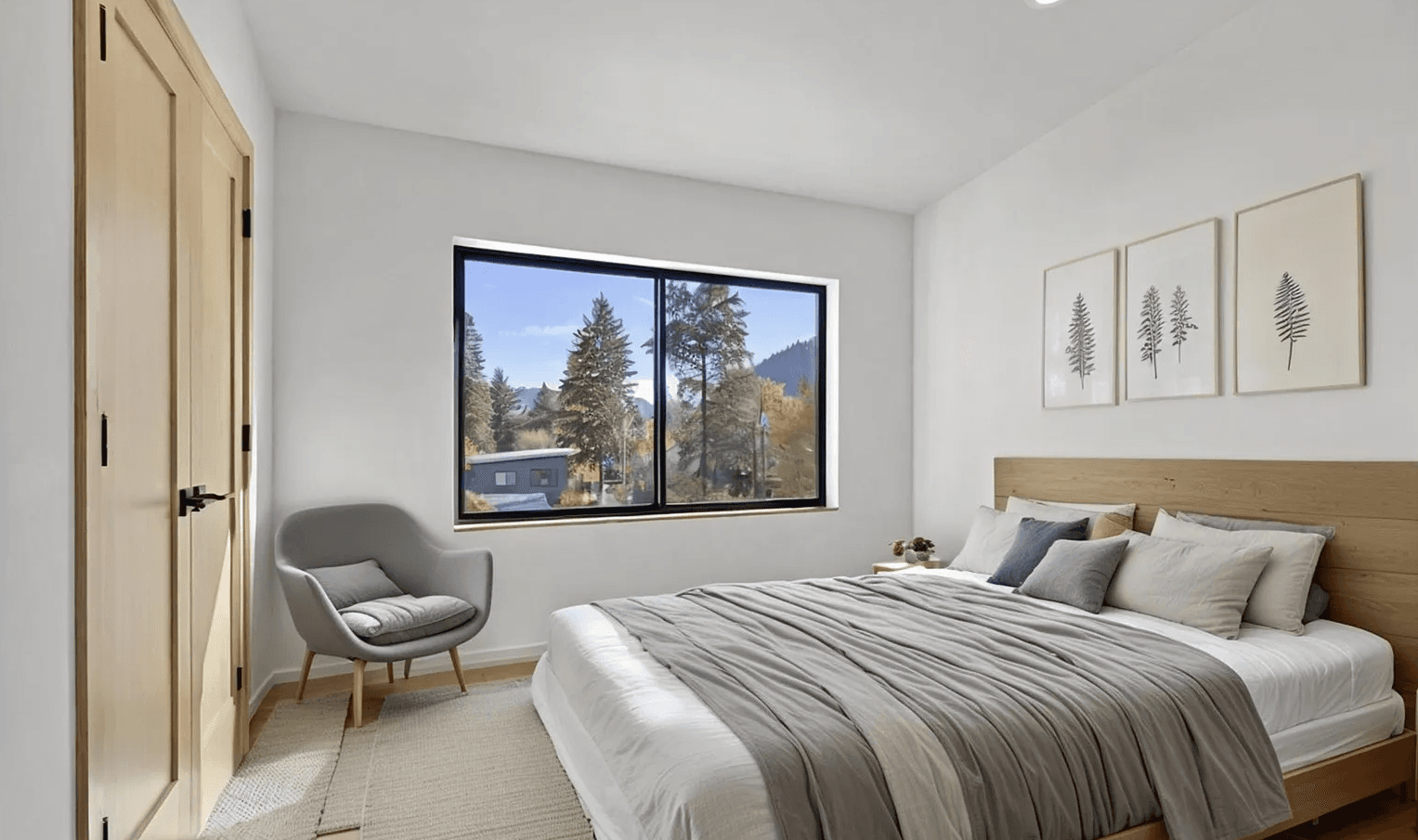 Interior of modern, newly constructed secondary bedroom with large bed, chair and closet
