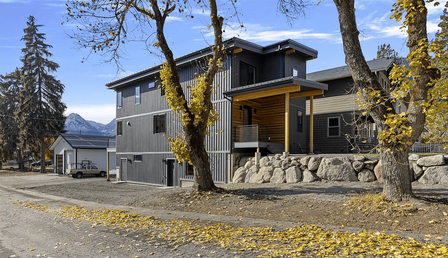 Side profile of modern three-story house with large windows and wooden accents