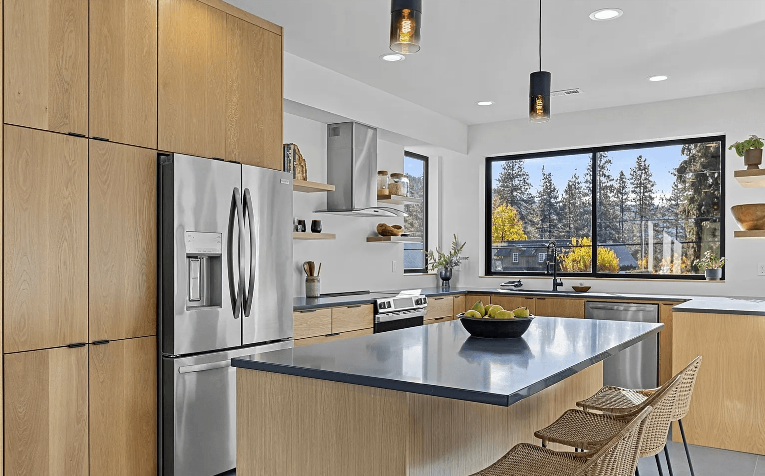Interior of modern, newly constructed kitchen with stainless steel appliances and dark counter tops