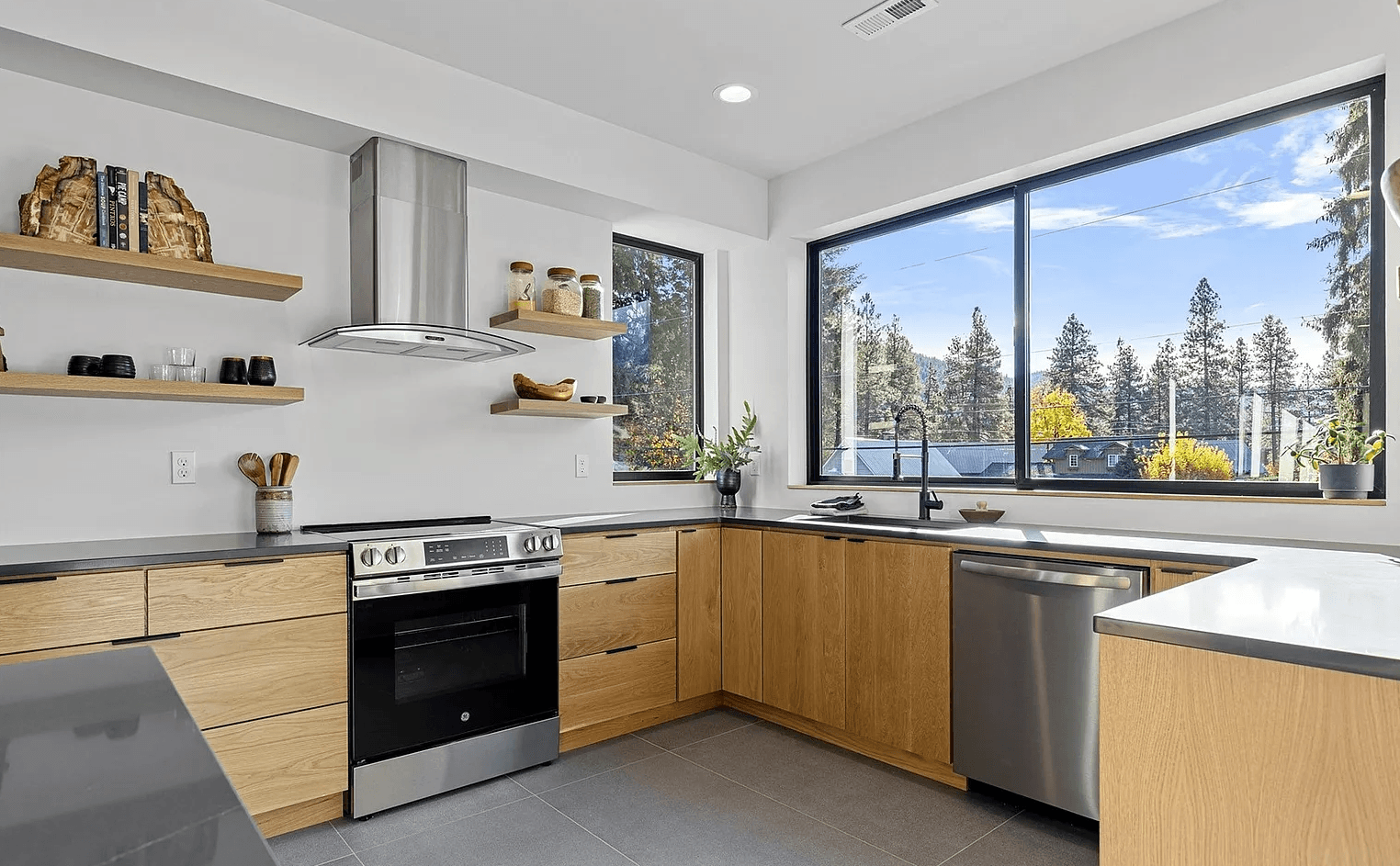 Interior of modern, newly constructed kitchen with stainless steel appliances and dark counter tops