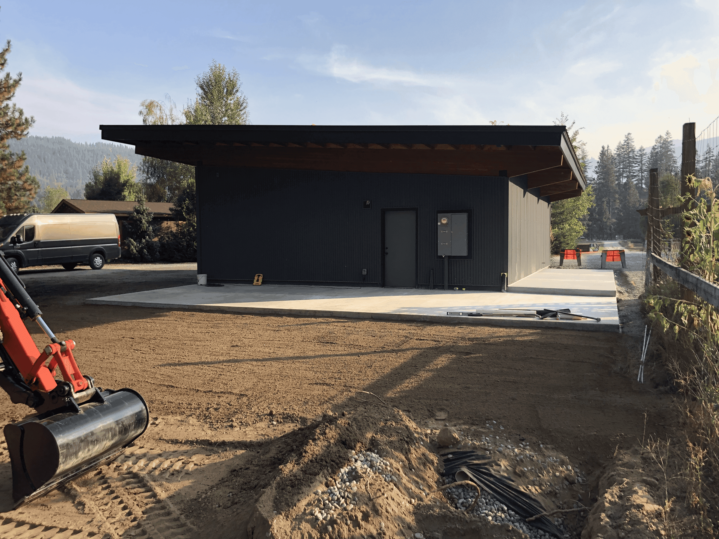 Finished double garage with black doors, grey siding and wooden accents