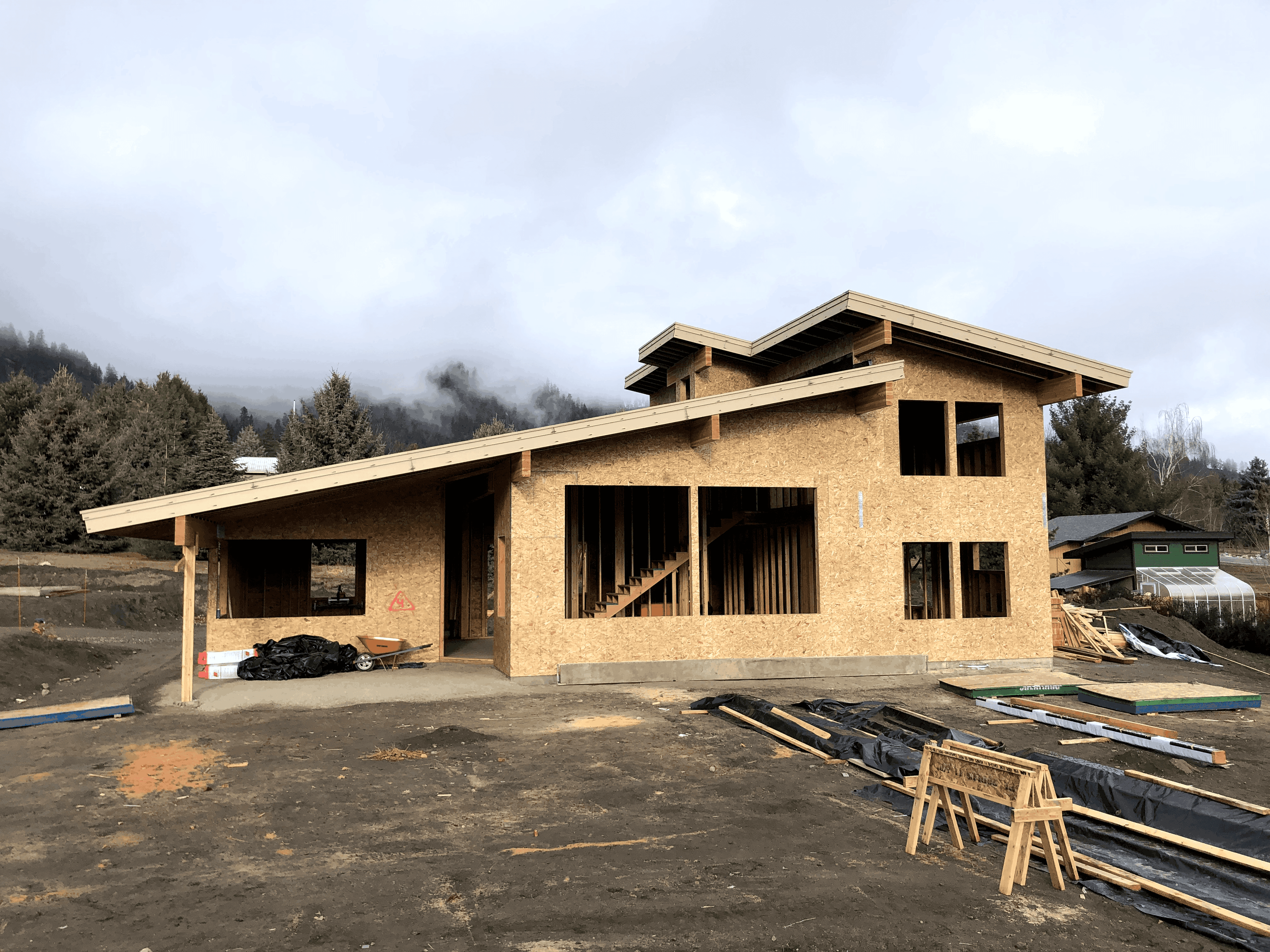 Exterior of home under construction with framing, walls and roofing complete