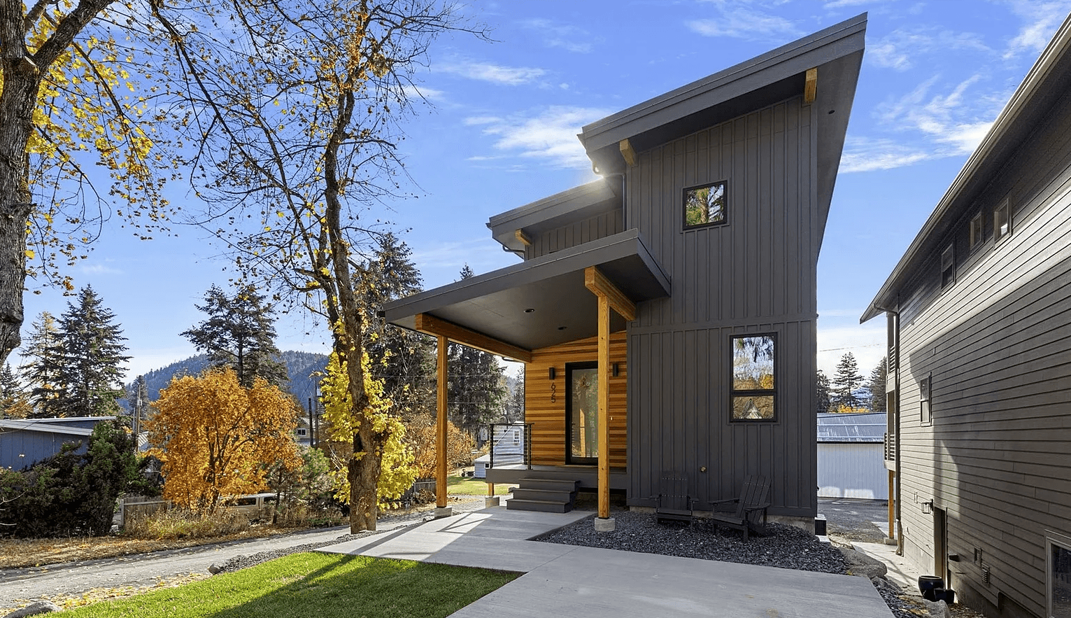 Front profile of modern two-story house with large windows and wooden accents