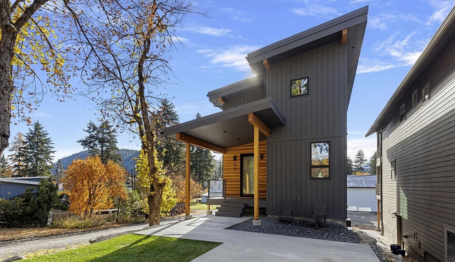 Front profile of modern two-story house with large windows and wooden accents